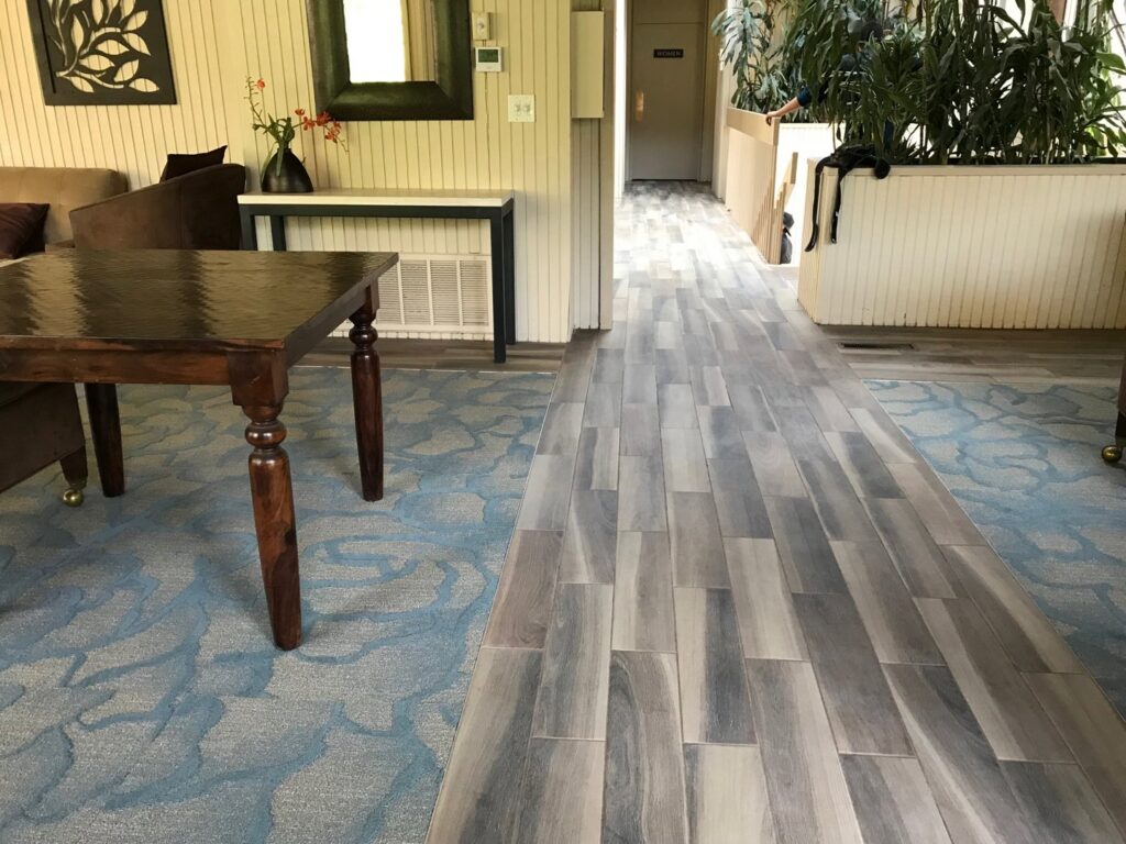 A commercial space featuring a combination of blue patterned carpet and grey plank flooring installed by LACarpetWarehouse in Los Angeles, CA.