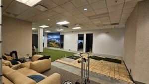 A commercial space with green artificial turf and subfloor, showing a flooring installation in progress by At Home Flooring in Naperville, IL.