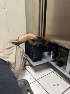 An HVAC technician repairing the condenser coil of a commercial freezer for Polar Air Heating and Cooling in Omaha, NE