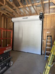 Commercial garage door with visible electrical conduits and wiring installation by Ernco Electric Inc. in Fresno, CA.