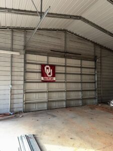 A newly installed white commercial garage door inside a metal building by 405 Garage Pros in Edmond, OK.