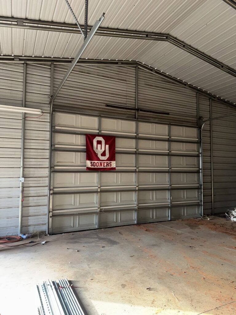 A newly installed white commercial garage door inside a metal building by 405 Garage Pros in Edmond, OK.