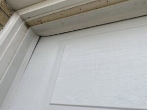 Two American Eagle Garage Doors service trucks at a commercial building with a large white garage door in Greeley, CO.