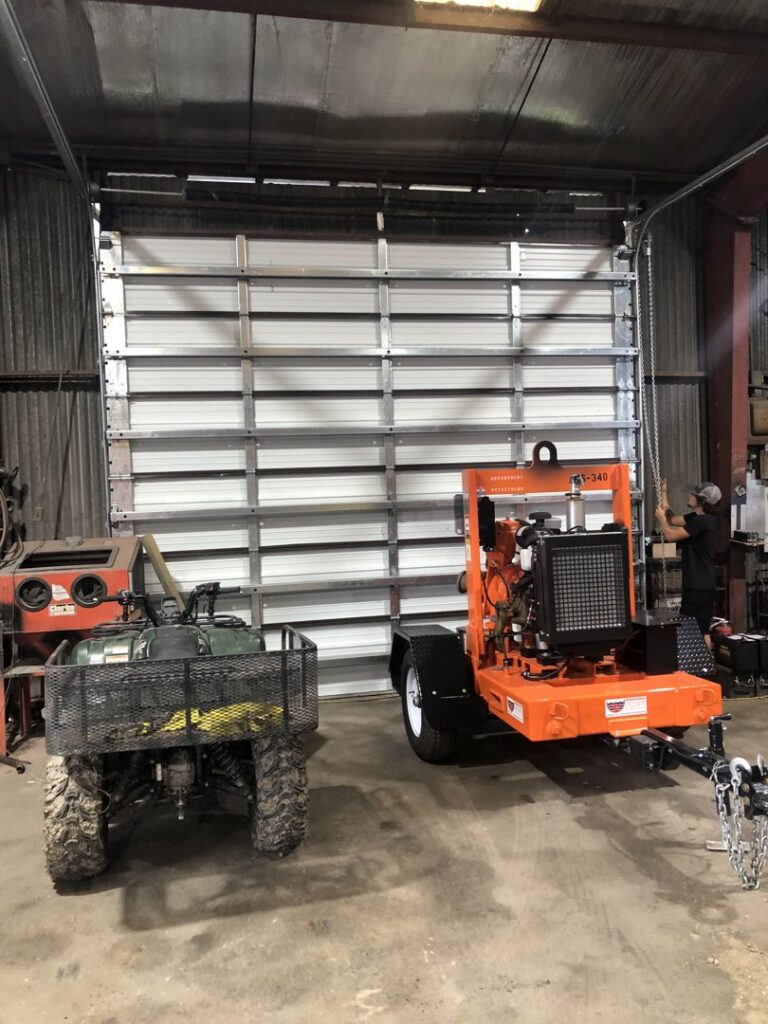 A commercial garage door with a chain hoist mechanism, indicating an installation or repair job by Superior Garage Door & Repairs in Lafayette, LA.
