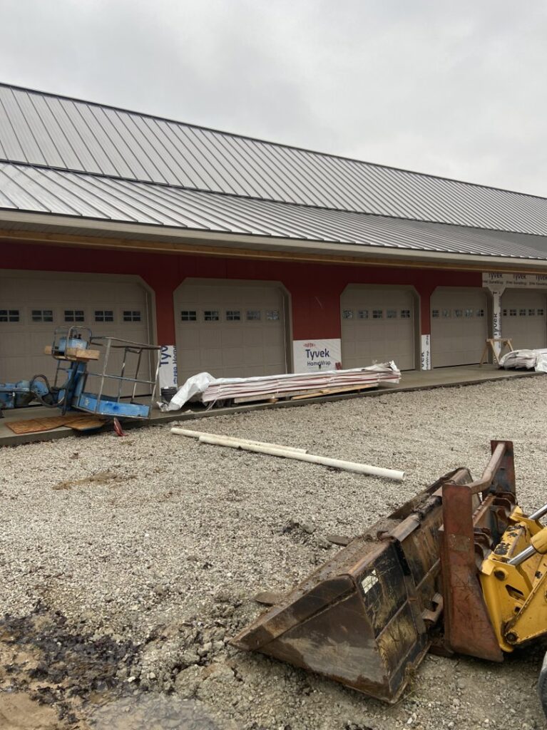 Multiple beige garage doors installed on a commercial building under construction by Garage Door Repair Company, LLC in Pueblo, CO.