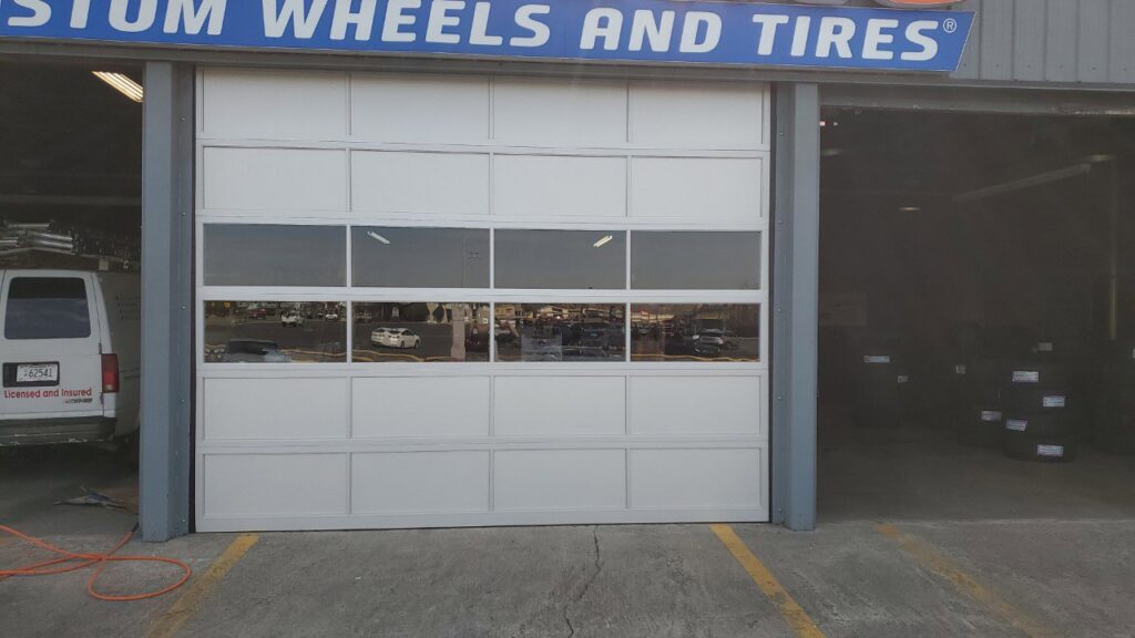 A commercial garage door with windows installed at Custom Wheels and Tires by Smith's Garage Door in Clarksville, TN.