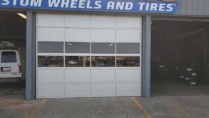 A commercial garage door with windows installed at Custom Wheels and Tires by Smith's Garage Door in Clarksville, TN.