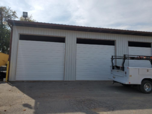 Commercial garage door installation with a work truck at a business by Midland Glass and Garage Doors in Frederick, MD