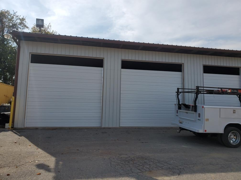 Commercial garage door installation with a work truck at a business by Midland Glass and Garage Doors in Frederick, MD