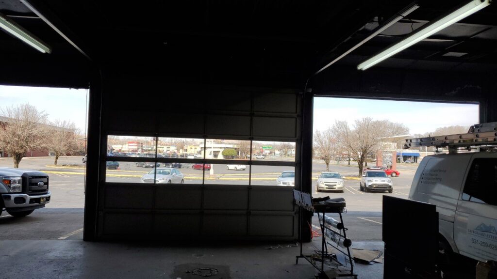 Interior view of a commercial garage door, partially open, installed by Smith's Garage Door in Clarksville, TN.