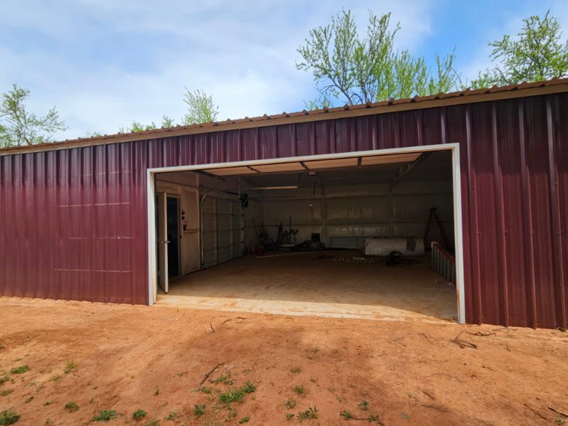An open garage door on a red metal commercial building, installed by Total Door Solutions in Yukon, OK