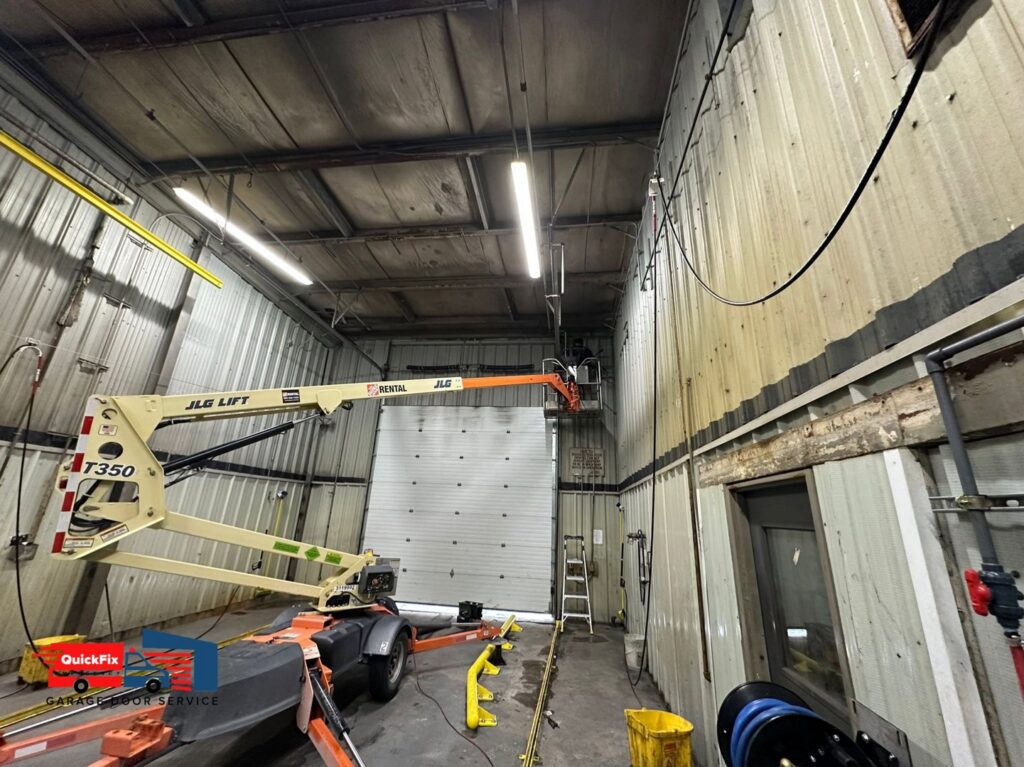 A commercial garage door with a lift positioned for repair or maintenance by QuickFix Garage Door Service in Brighton, MA.