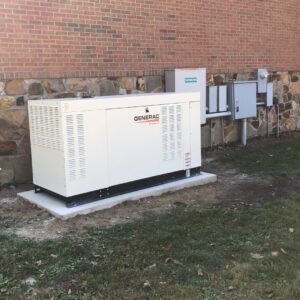 A commercial Generac standby generator installation with electrical panels on a brick building by Electric Today in Indianapolis, IN.
