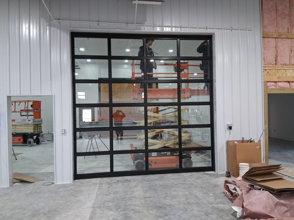 Installation of a commercial glass garage door by Usa Garage Door Services and Construction, LLC at 1206 E 6th St, USA.