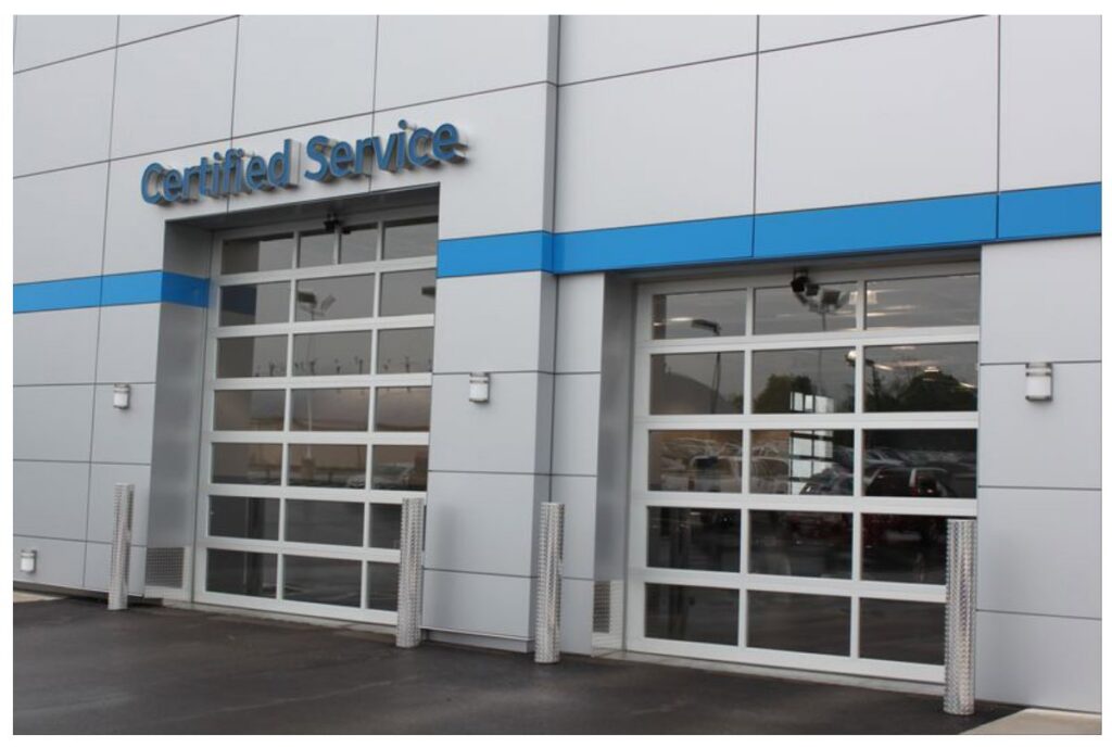 Two modern commercial glass garage doors on a 'Certified Service' building, installed by Geiszler Garage Door in Milwaukee, WI.