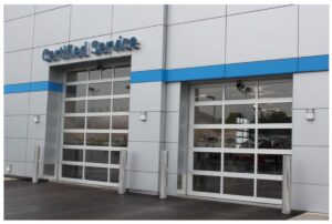 Two modern commercial glass garage doors on a 'Certified Service' building, installed by Geiszler Garage Door in Milwaukee, WI.