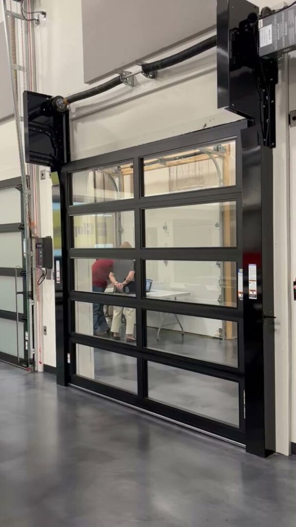Modern black frame glass overhead door installed in a commercial space by Magic City Door in Birmingham, AL.