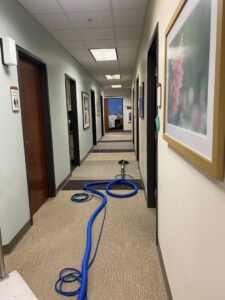 Carpet cleaning equipment set up in a commercial hallway for professional service by The Floor Care Guys in Bentonville, AR.