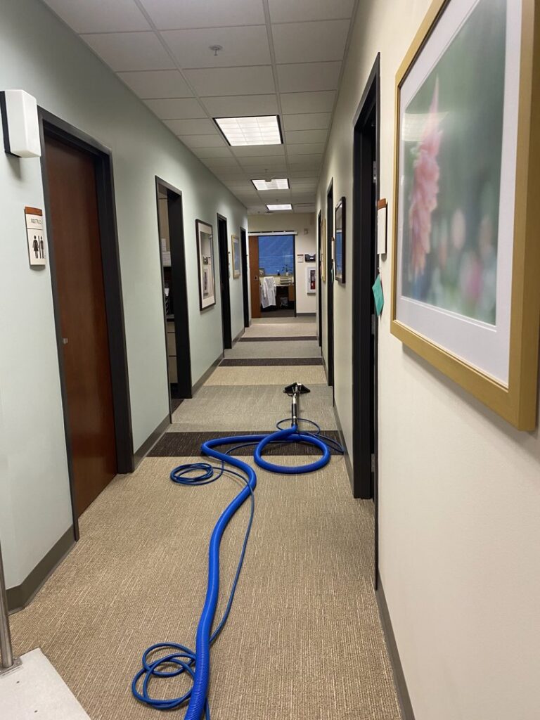 Carpet cleaning equipment set up in a commercial hallway for professional service by The Floor Care Guys in Bentonville, AR.