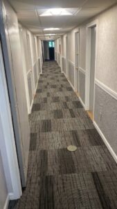 A commercial hallway showcasing a modern carpet tile installation by Essex Companies LLC in Salem, NH.
