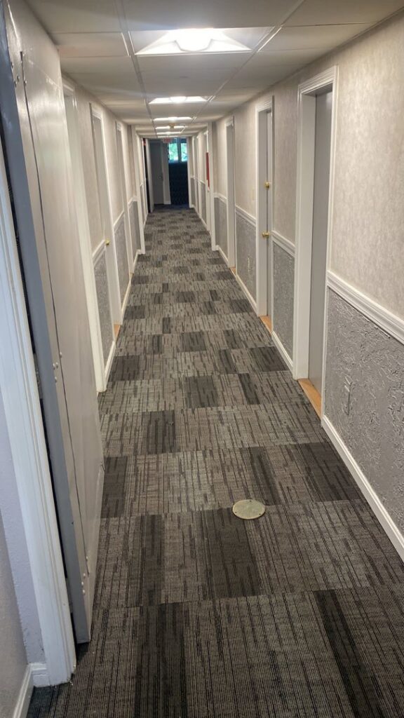 A commercial hallway showcasing a modern carpet tile installation by Essex Companies LLC in Salem, NH.