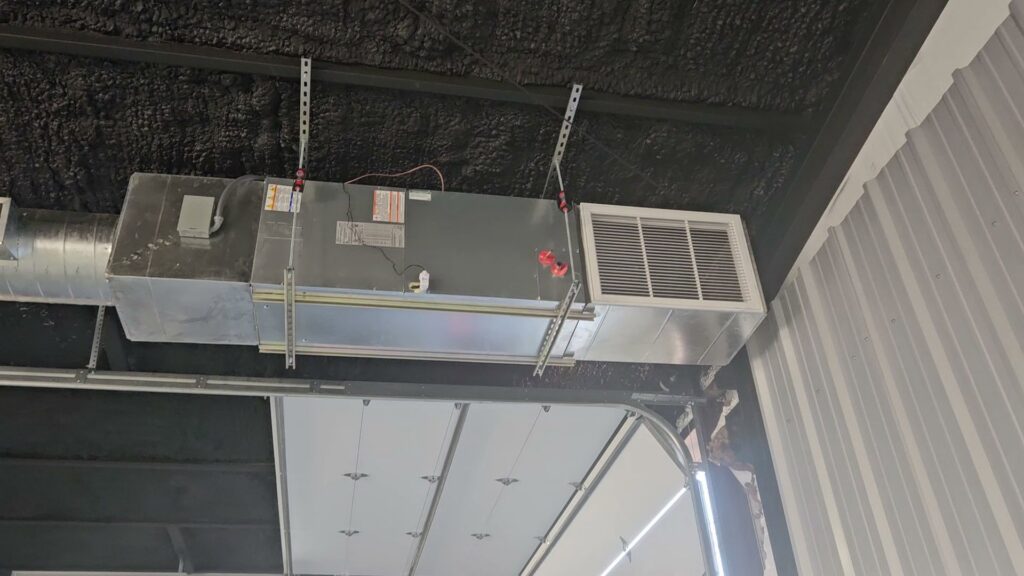 A commercial HVAC air handler and ductwork system installed and suspended from a ceiling by HoxAir Heating & Cooling in Phoenix, AZ