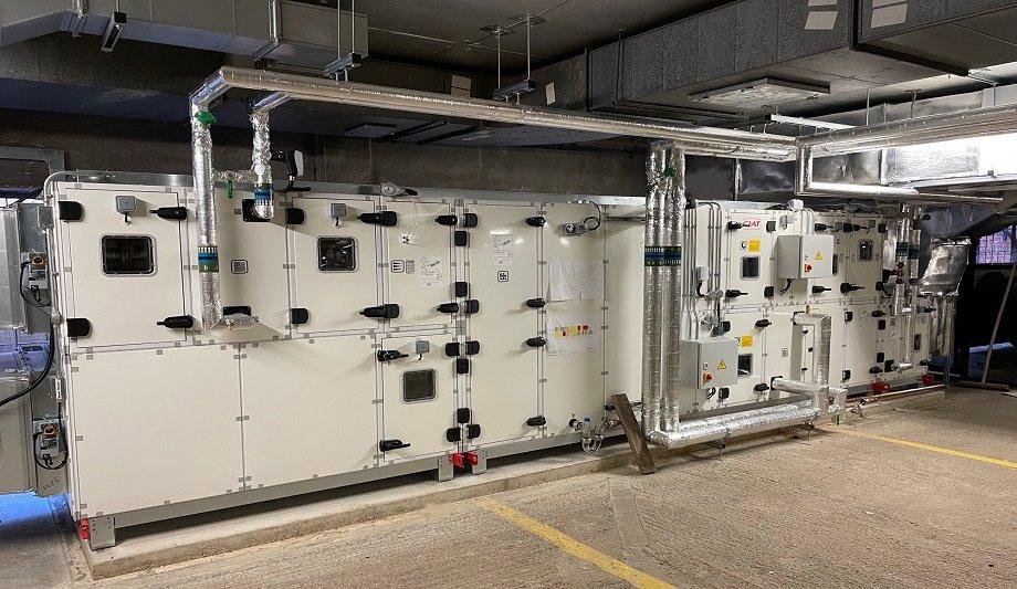 Large commercial HVAC air handling units and ductwork in a mechanical room, serviced by Furnace Doctors Heating & Air Conditioning LLC in Champaign, IL