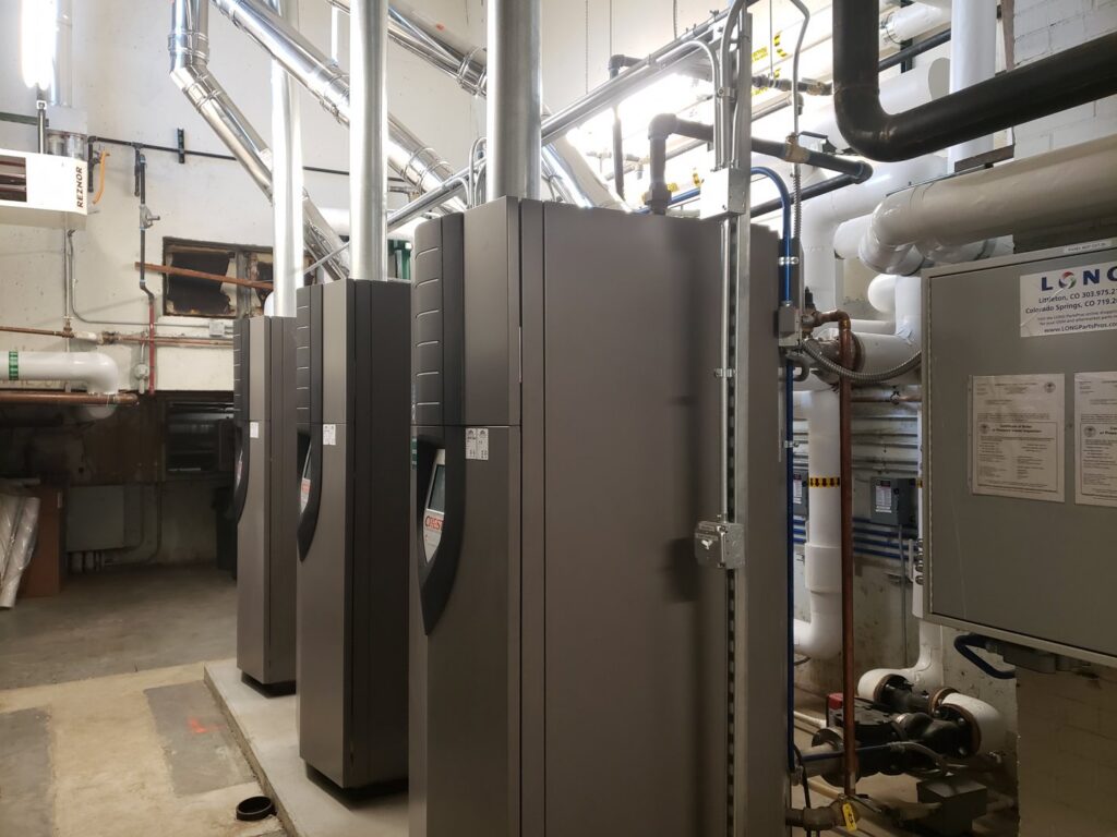 A row of commercial HVAC boilers and associated piping installed by HVAC Solutions in Colorado Springs, CO