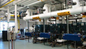 A commercial boiler room with extensive piping and HVAC units installed by J&M Heating and Air Conditioning, Inc. in New Rochelle, NY.