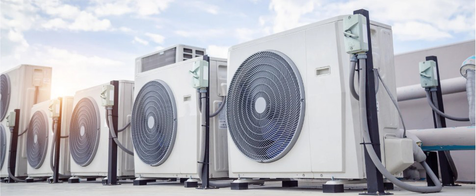 A row of outdoor commercial HVAC condenser units on a rooftop by Arctic Desert Cooling & Heating in Concord, NC