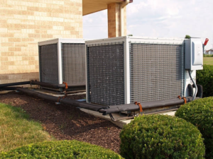 Two large commercial HVAC condenser units installed outside a building by Infinity Heating & Cooling by Rivera in Kenosha, WI.