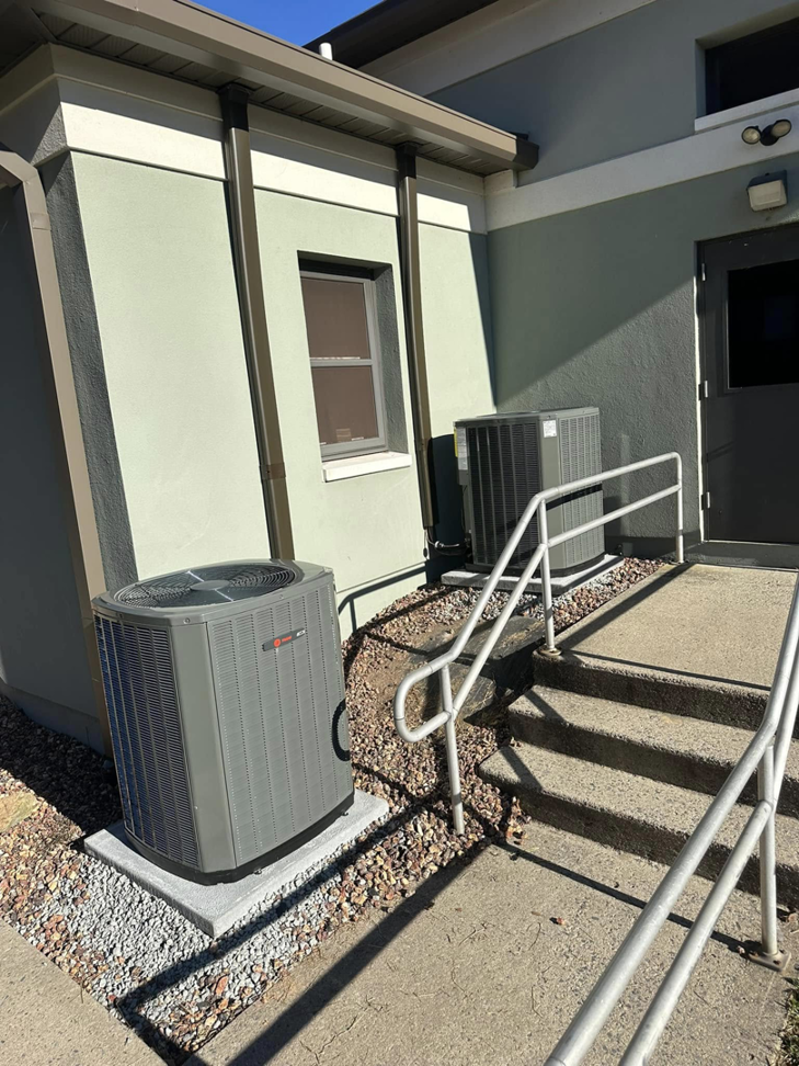 Two commercial HVAC condenser units installed outside a building entrance by R&R Climate Systems in Newark, NJ
