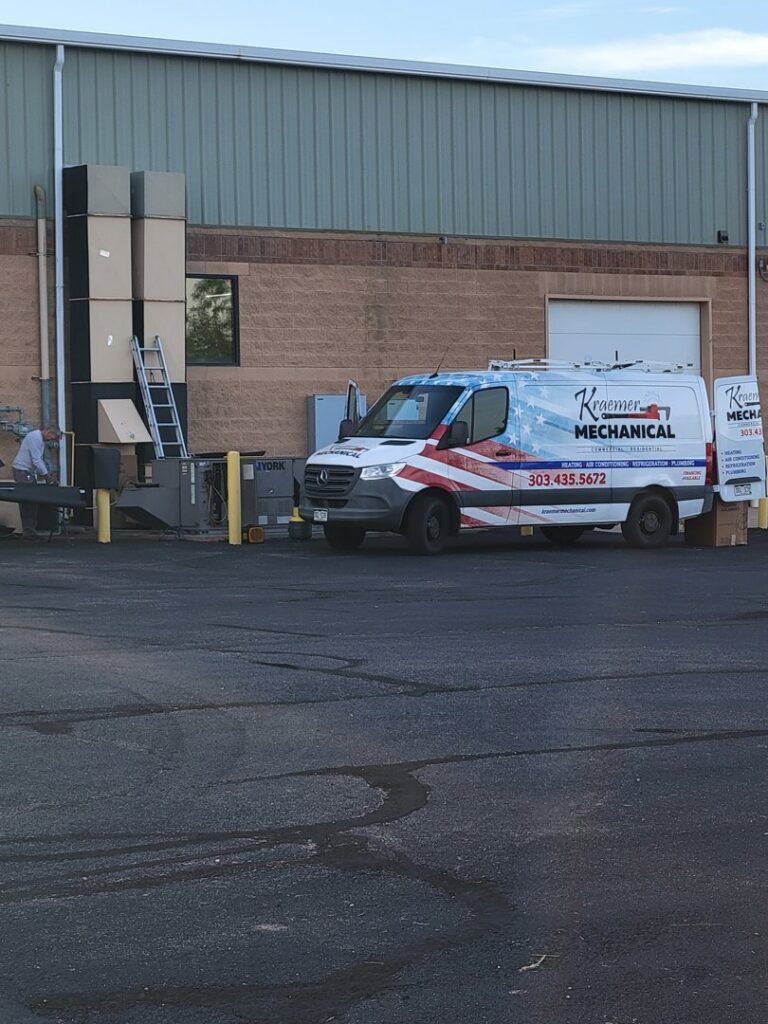 Kraemer Mechanical service van at a commercial site with HVAC ductwork boxes in Broomfield, CO.