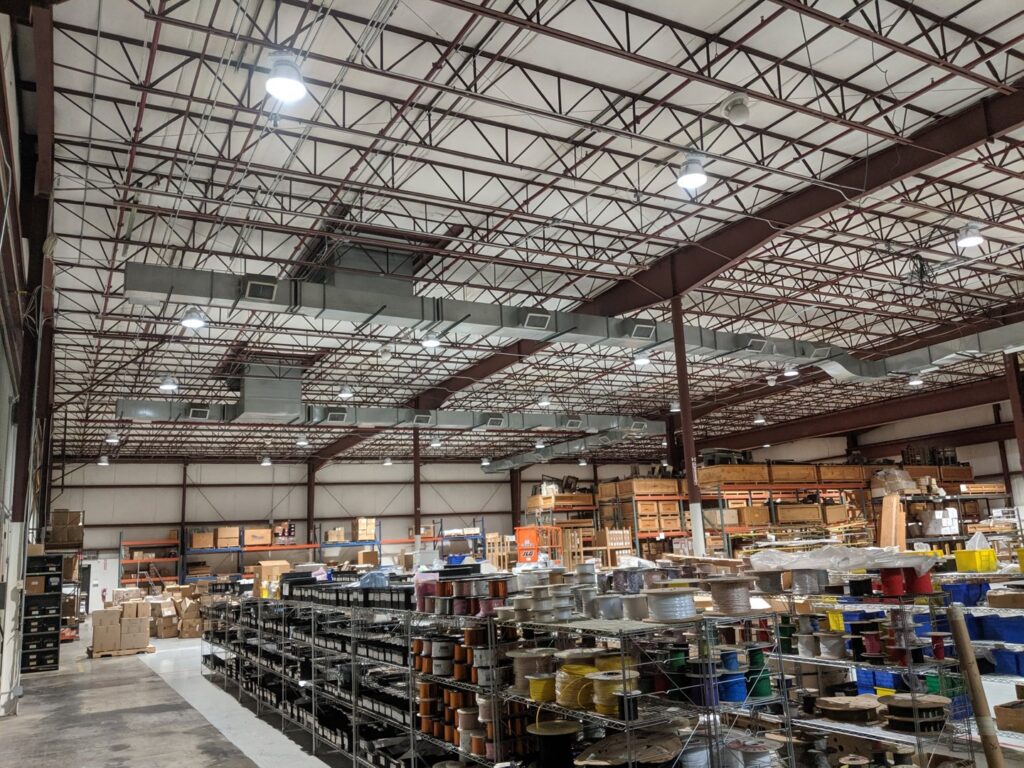 Extensive HVAC ductwork and lighting installed in a large commercial warehouse by Bryant-Durham Services in Durham, NC.