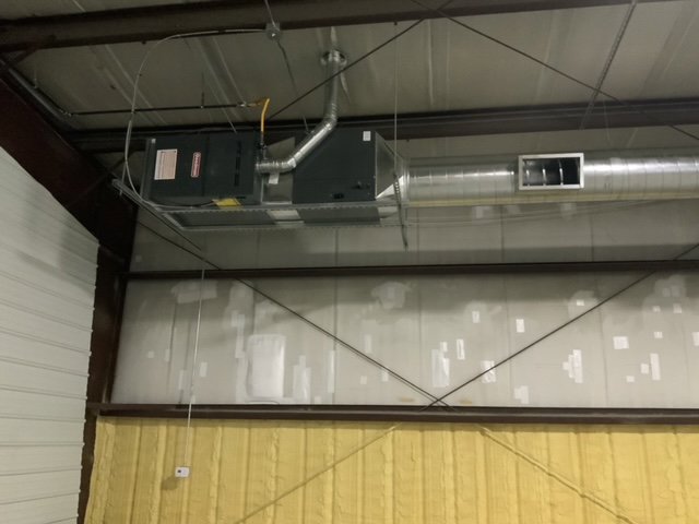Commercial HVAC unit and ductwork suspended from a ceiling by Chill Out Heating and Cooling in Tulsa, OK.