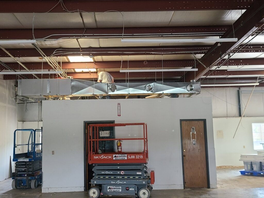Commercial HVAC ductwork being installed in a large open space by Cool y Caliente HVAC Services in Bonner Springs, KS.