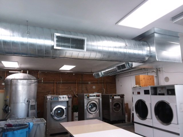Large exposed commercial HVAC ductwork installation in a laundry facility by Element Heating & Cooling, Inc. in Twin Falls, ID
