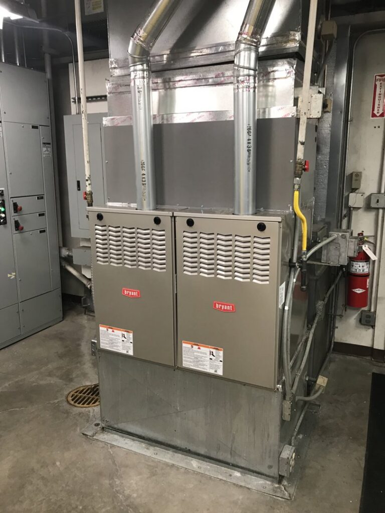 Two large commercial HVAC furnaces or air handlers with ductwork installed by DeHart Plumbing, Heating, & Air in Sparks, NV.