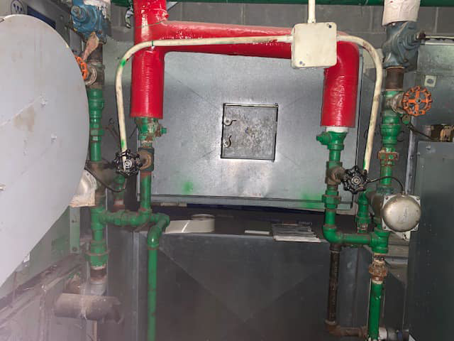 A commercial HVAC heat exchanger system with red and green pipes serviced by Allstate Heating & Cooling in Lexington, KY.