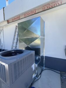 Commercial HVAC installation with an outdoor AC unit and new sheet metal ductwork on a rooftop by OnPoint Heating and Air in Commerce City, CO.