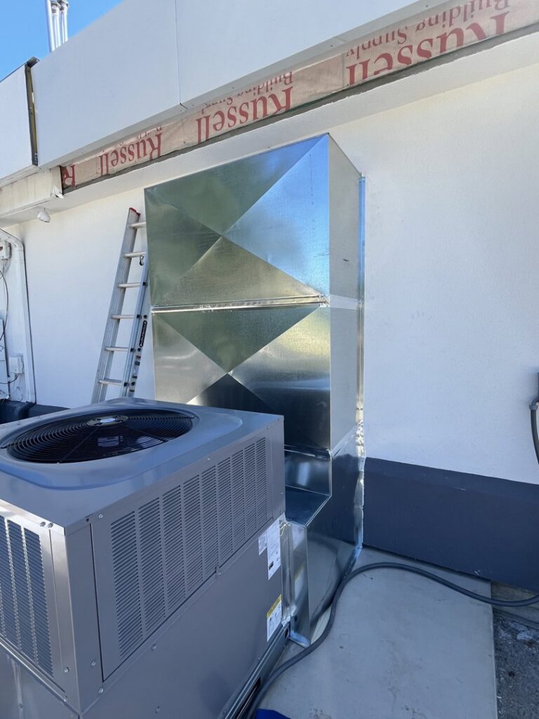 Commercial HVAC installation with an outdoor AC unit and new sheet metal ductwork on a rooftop by OnPoint Heating and Air in Commerce City, CO.