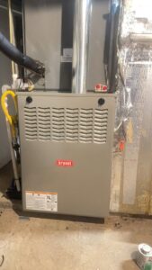 An outdoor commercial HVAC unit with vertical ductwork and a ladder, installed by Ware's Heating & Cooling in Georgetown, KY.