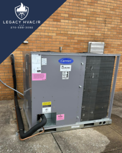 A large outdoor commercial Carrier HVAC package unit installed against a brick wall by Legacy Hvac/r in Libertyville, IL.