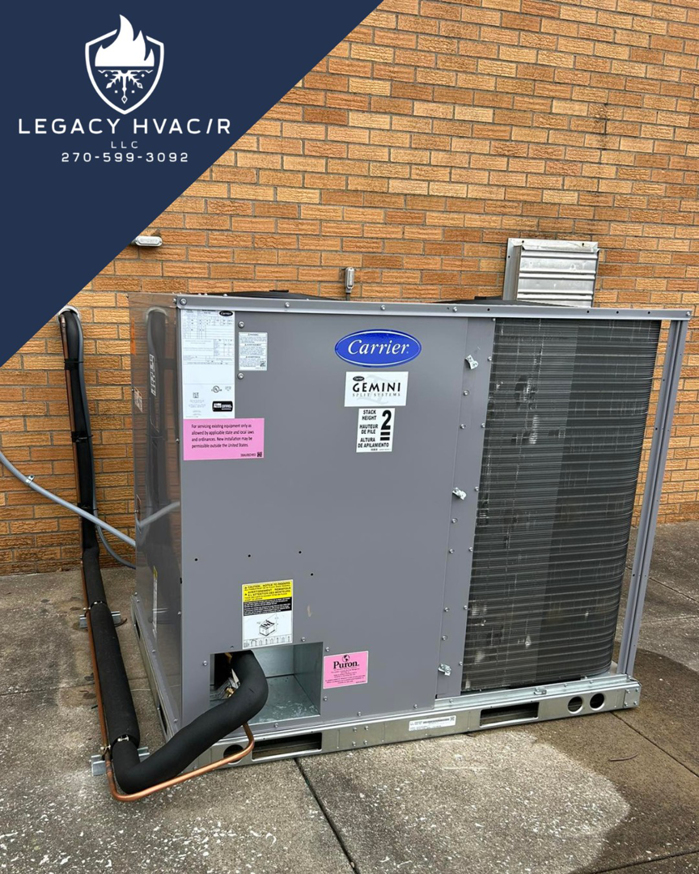 A large outdoor commercial Carrier HVAC package unit installed against a brick wall by Legacy Hvac/r in Libertyville, IL.