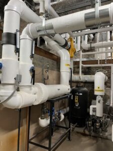 A complex commercial HVAC and plumbing piping system with insulated pipes and valves, serviced by Heinz HVAC & Plumbing in Vincennes, IN.