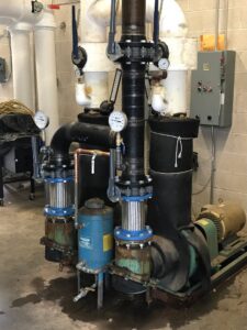 Large commercial HVAC pumps and intricate piping system installed by Evergreen Services in Warwick, RI.
