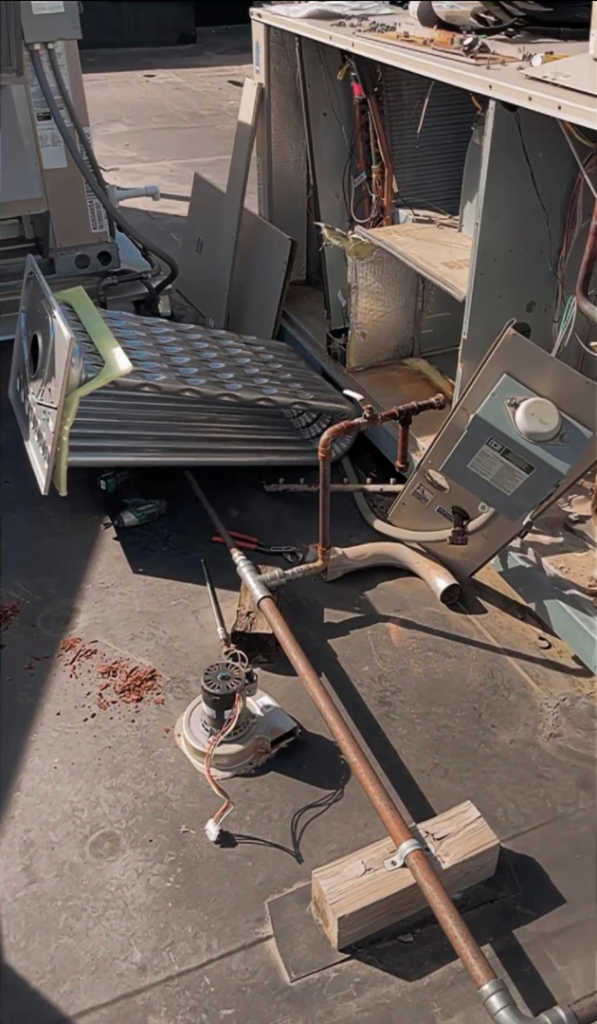 A commercial HVAC unit disassembled for repair on a rooftop by Schomp's Mechanical Services in Brookings, SD.