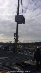 A commercial HVAC rooftop unit being installed with a crane by Cannon Heating and Air Conditioning, LLC in Newport News, VA.