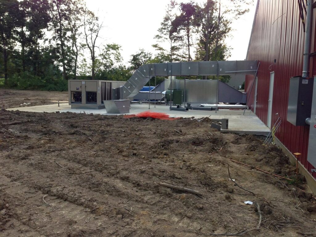 Newly installed commercial HVAC units and ductwork on a concrete pad by AireCom HVAC in Columbus, OH.