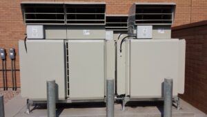Exterior view of commercial HVAC systems installed by ABT Heating and Cooling next to a brick building in Orem, UT.